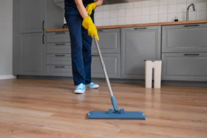 Person mopping vinyl flooring with mild cleaner for easy maintenance
